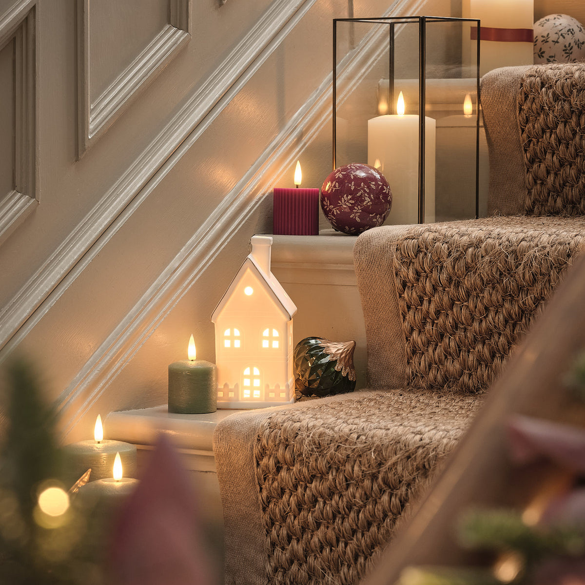 Großes weißes LED-Keramikhaus mit warmweißen LEDs und Timer-Funktion beleuchtet dekoriert auf der Treppe