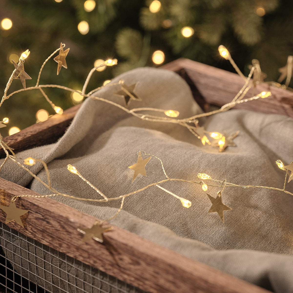 1,5m LED-Sternenlichterkette in Gold mit 50 Mikro-LEDs beleuchtet dekoriert auf einem weihnachtlichen Korb