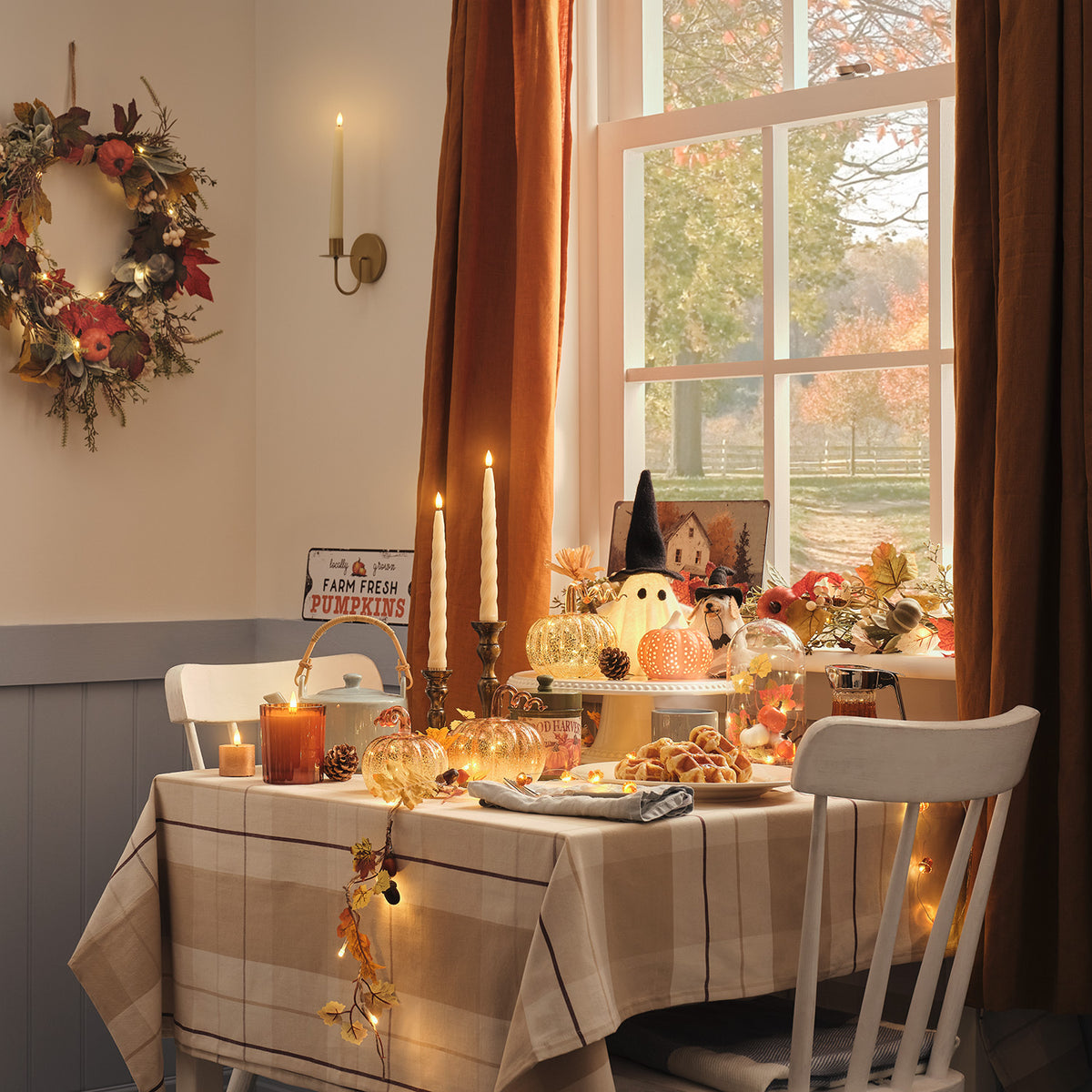 2er Set TruGlow® LED-Stabkerzen mit Wandhaltern & Fernbedienung gehängt neben Herbsttisch
